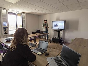 Une personne en formation face à un formateur